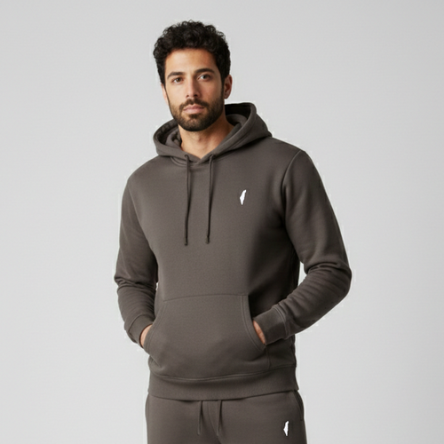 Man wearing a brown tracksuit with a logo on a light gray background