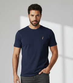 Man wearing a navy blue t-shirt with a small logo on a light gray background