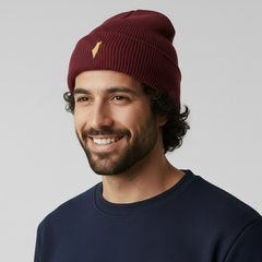 Man wearing a maroon beanie with a logo on a plain background