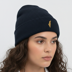 Woman wearing a navy blue beanie with a gold logo on a light gray background